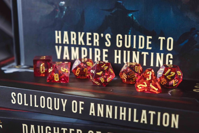 Red polyhedral dice set on top of a book titled 'Soliloquy of Annihilation'.