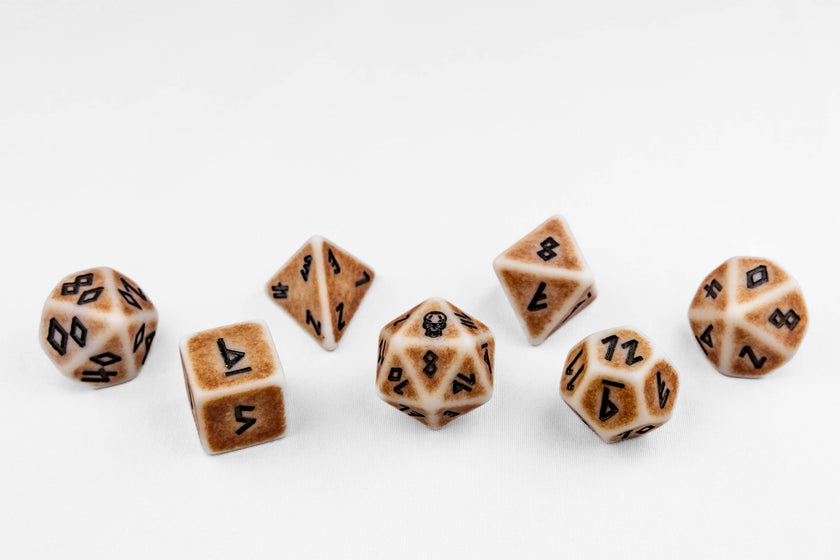 Set of seven polyhedral dice in ivory and aged brown with black numbering on a white background.